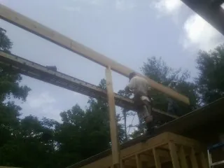 Carpenter setting a ridge beam over a new addition frame — Ice Dam Removal by Roofing Brothers in West Ossipee