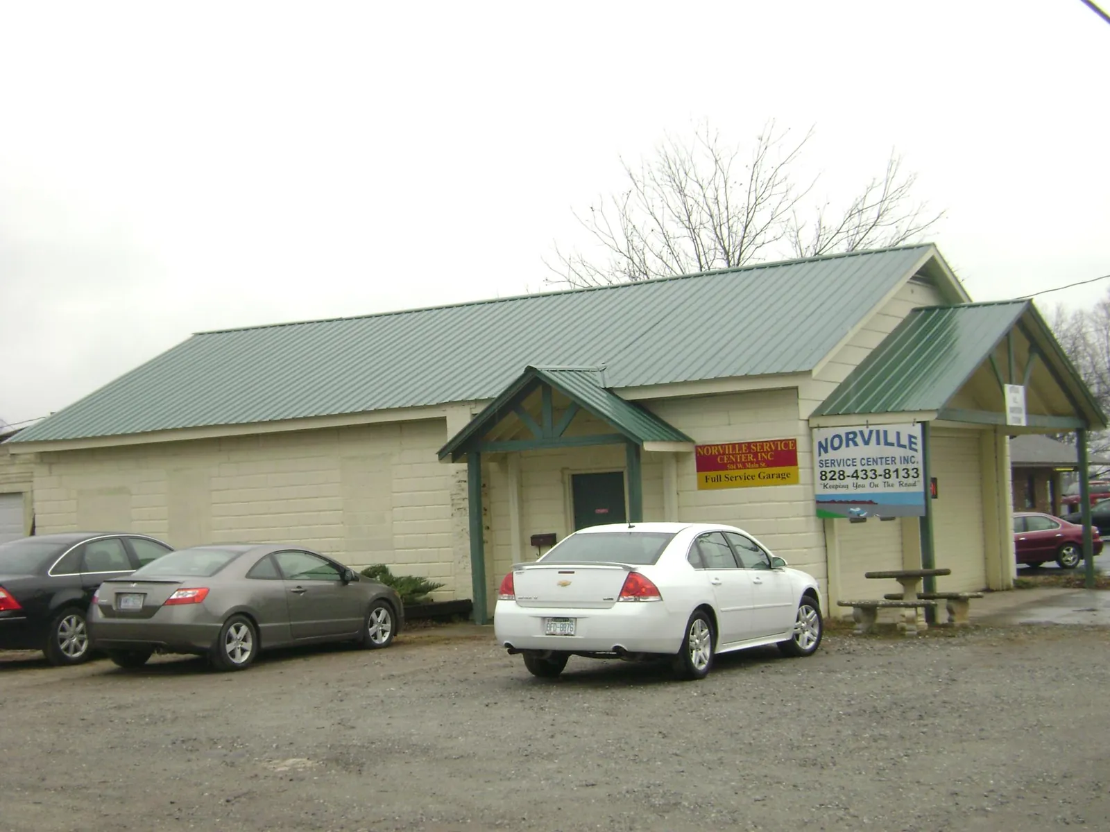 Green metal roof on a service garage with a covered entry in West Ossipee