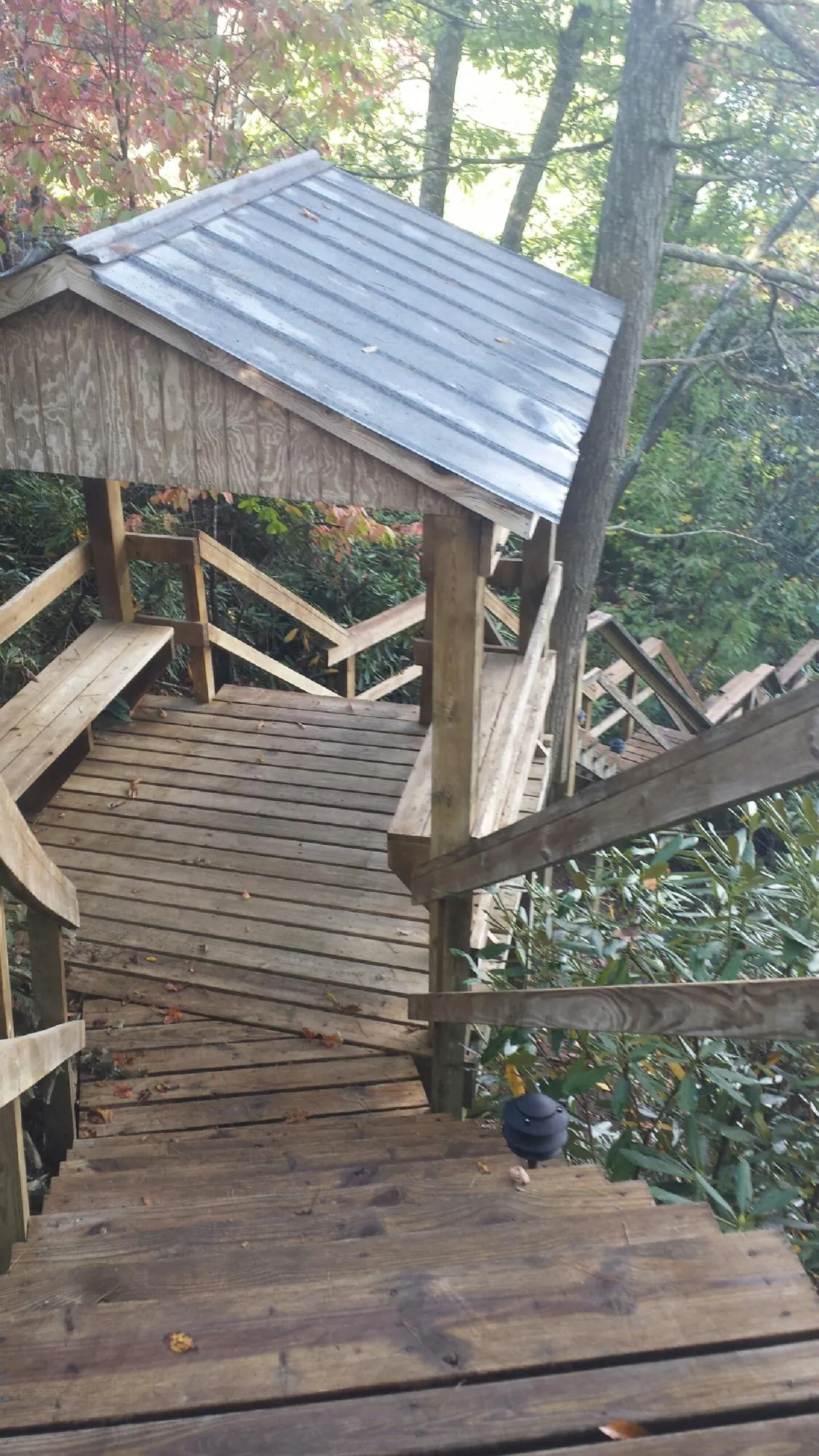 Metal roofed shelter over wooden steps on a wooded walkway — Skylight Repair & Installation work by our crew in West Ossipee
