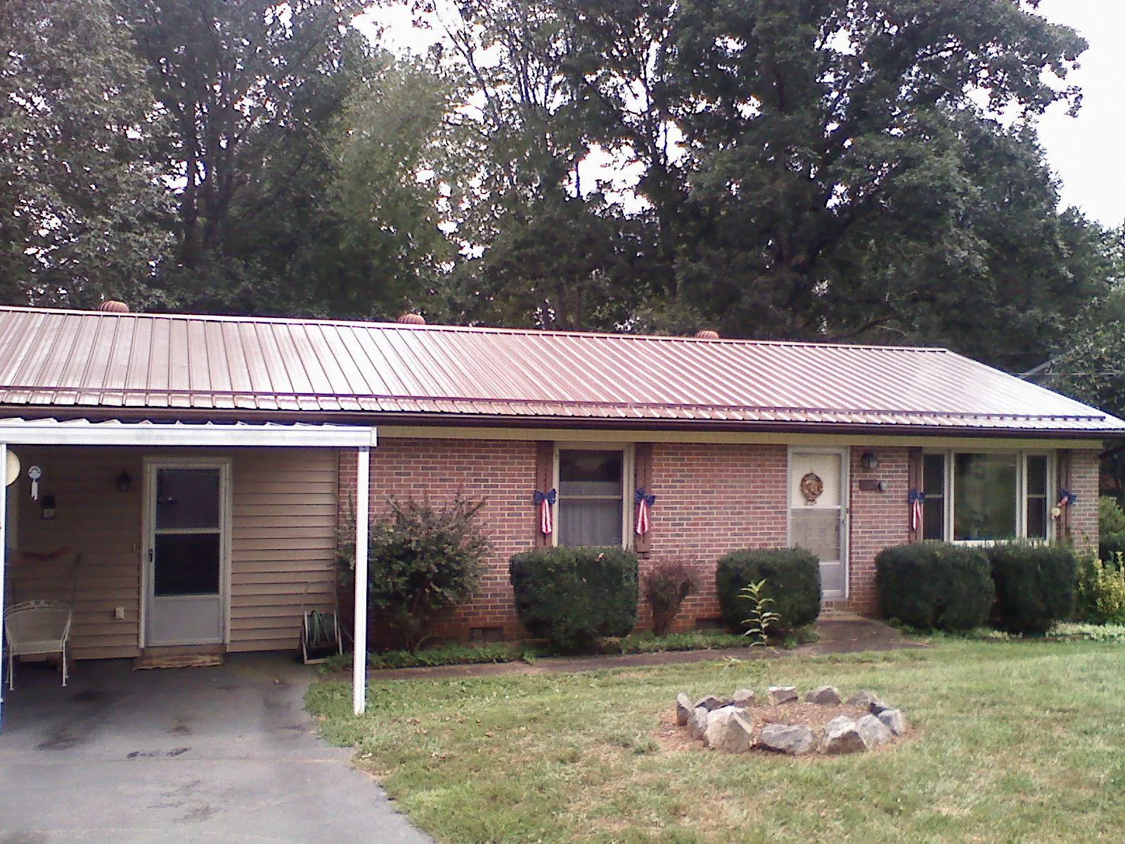 Bronze metal roof and carport on a brick ranch home — Roof Repair work by our crew in West Ossipee
